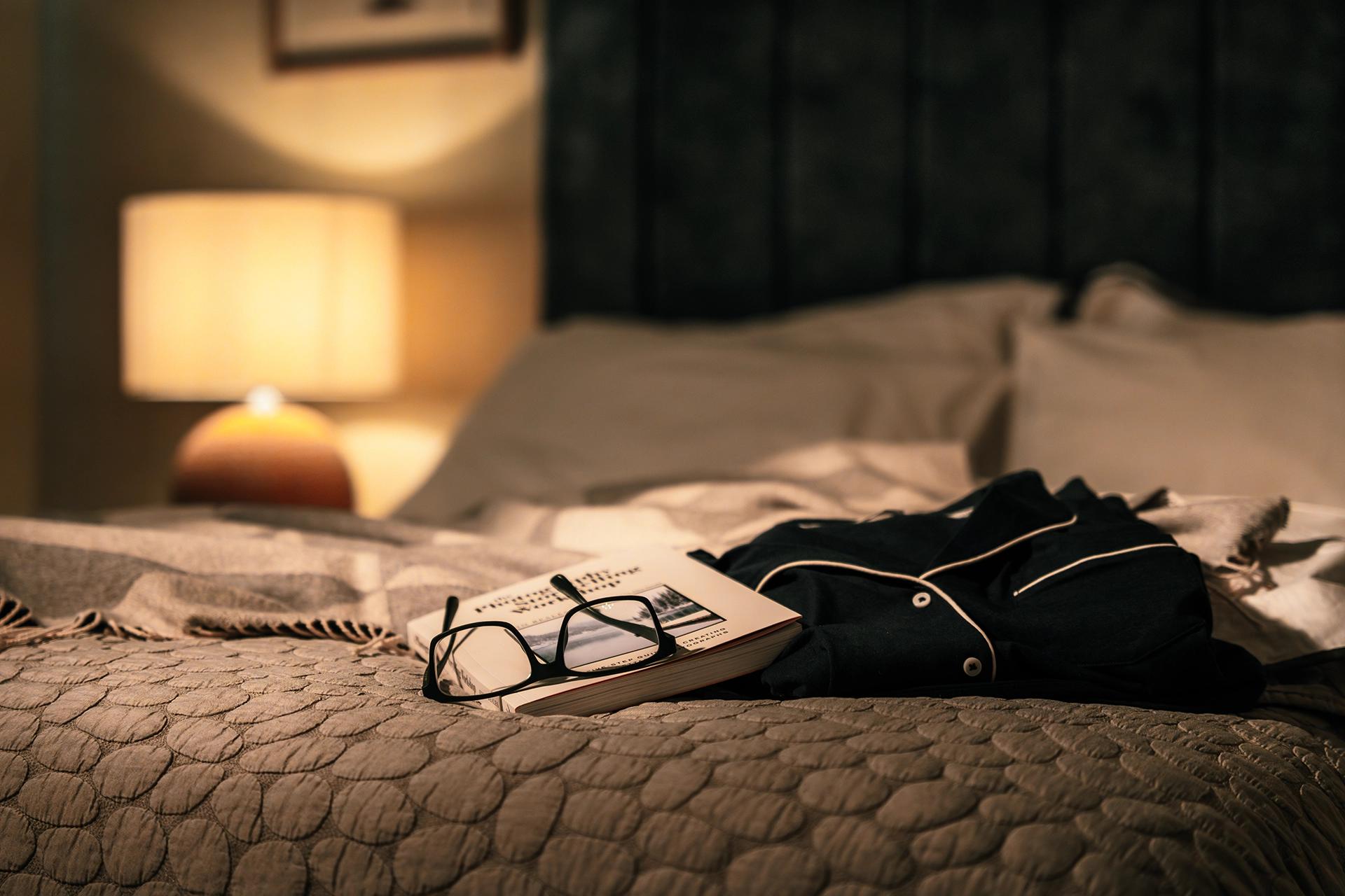 Book, Glasses & PJs on bed