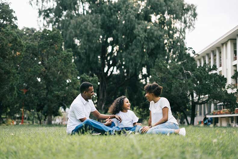 Family sitting down in the park having a picnic