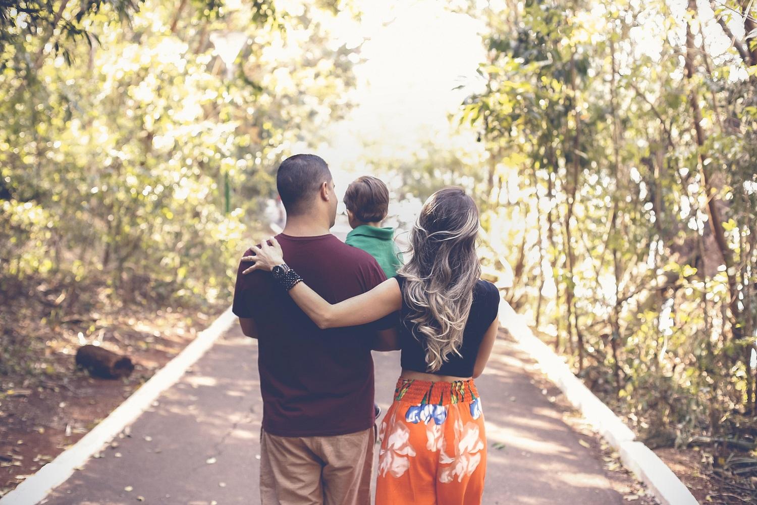 Family walking on path through trees