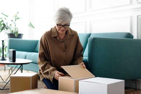 women unpacking brown boxes in living room